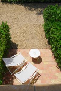 two chairs and a table on a brick patio at Hôtel La Figuière in Saint-Tropez