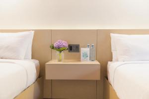 a table with a vase of flowers on it between two beds at Hotel Boutique Rebequet in Boquete