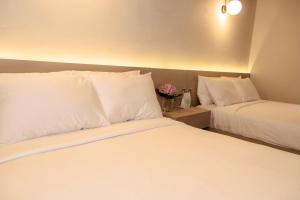 a hotel room with two beds with white pillows at Hotel Boutique Rebequet in Boquete