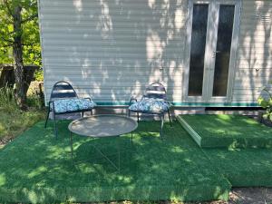 a patio with two chairs and a table on the grass at Cabanon dans le jardin in Gaillac