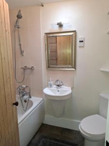 a bathroom with a sink and a tub and a toilet at Aberlour Cottages - Bolthole & Retreat in Aberlour +26 photos