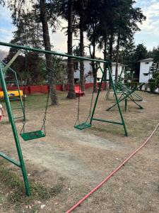 an empty playground with swings in a park at Shikha Resort Ewentbliz in Bhīm Tāl