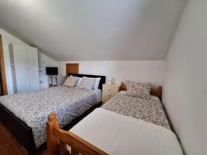 a bedroom with two beds and a small bedskirts at Cantinho do Mel in Castro Daire