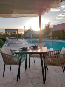 a table and chairs next to a swimming pool at Alesia - Boutique Hotel & Spa in Aguascalientes