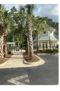 a building with palm trees in front of a street at First Class Treatment Luxurious end unit Patio Pool Restaurant Bar on premises Steps away from Everything else! Spacious Condo Stocked with all You Need! in Myrtle Beach