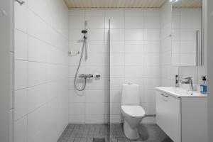a bathroom with a shower and a toilet and a sink at Upea yksiö joen läheisyydessä in Turku +12 photos