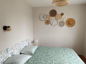 a bedroom with a bed with plates on the wall at La Maison de LULU proche baie de Somme in Eu