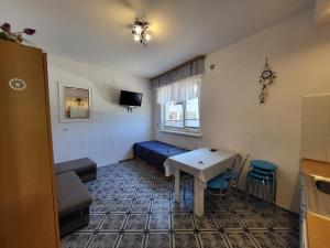 a room with a bed and a table and chairs at Studio-tani apartament in Rowy