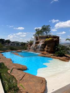 a pool in a resort with a waterfall at Pousada do Batata in Capitólio