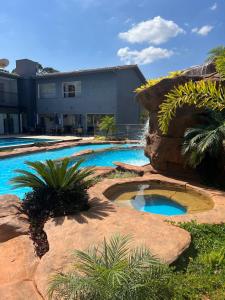 a swimming pool with a rock wall next to a building at Pousada do Batata in Capitólio