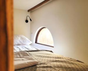 a bedroom with a bed and a window at Caracola Boutique Hostel in El Paredón Buena Vista