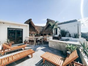 a patio with two benches and a table and chairs at Caracola Boutique Hostel in El Paredón Buena Vista