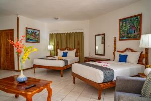 a hotel room with two beds and a couch at Merrils Beach Resort II in Negril
