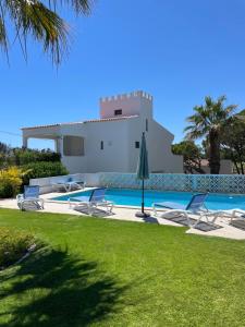 a villa with a swimming pool and a house at Vila Castelo in Vale do Lobo