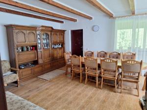 a dining room with a wooden table and chairs at Sătic Casa Maria in Sătic