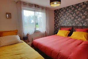 two beds sitting next to a window in a bedroom at Gîte au bord du lac - 4-10 pers - La Roche sur Yon in La Roche-sur-Yon