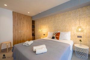 a bedroom with a large bed with towels on it at Magisto Loft in Nea Moudania