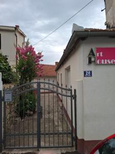 une porte en face d'un bâtiment aux fleurs roses dans l'établissement Art house 1, à Mostar