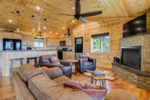 a living room with a couch and a fireplace at Gorgeous Gatlinburg Cabin Large Deck and Hot Tub! in Gatlinburg