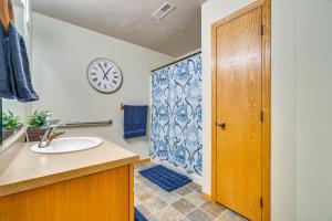 a bathroom with a sink and a clock on the wall at Cozy Sioux Falls House - Walk to Park! in Sioux Falls +19 photos