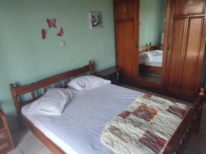 a bedroom with a bed with a wooden frame and a mirror at Varagas Bliss in Sívros