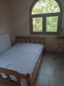a bed in a room with two windows at Varagas Bliss in Sívros +12 photos