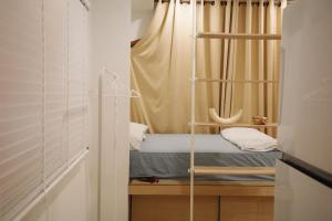 a small room with a bed with a curtain at Daisy B in Hat Yai