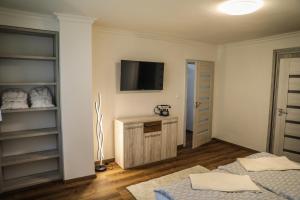 カルロヴィ・ヴァリにあるApartment Irmaのベッドルーム1室(壁にテレビ付)、ベッド1台が備わります。
