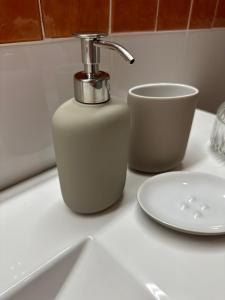 a soap dispenser on a counter next to a cup at Apartamento St Agustí - Centric in Mataró