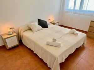 a bedroom with a large bed with towels on it at Apartamento St Agustí - Centric in Mataró