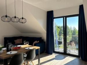 een eetkamer met een tafel en een glazen deur bij Apartamenty La Venda in Darlowko