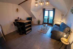 ein Wohnzimmer mit einem blauen Sofa und einem Schreibtisch in der Unterkunft Le Doux Art de Vivre - Studio 2 personnes avec vue in Doussard