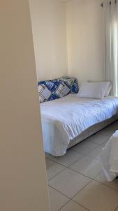 un lit avec des draps blancs et des oreillers dans une chambre dans l'établissement Talabay resort, à Al Burj