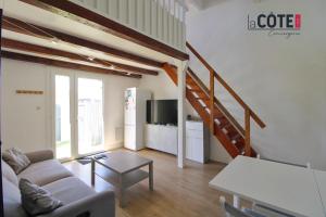 a living room with a couch and a staircase at Villa Mozart - 6 couchages in Sausset-les-Pins