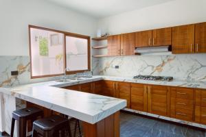 a kitchen with wooden cabinets and a white counter top at Casa La Martina Holbox in Holbox Island