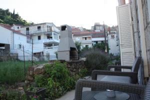a balcony with two wicker chairs and a stone fireplace at Apartment Ivan in Račišće