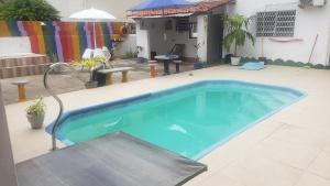 a large swimming pool in a yard with an umbrella at Pousada e Hostel Sol e Mar in João Pessoa