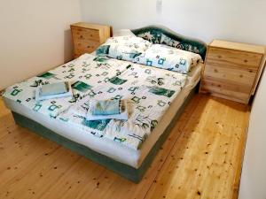 a bedroom with a bed and a wooden floor at Németh Apartmanház in Balatongyörök