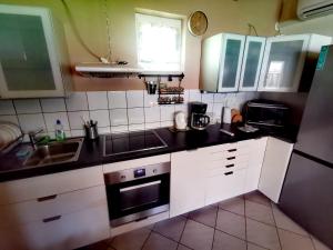 a kitchen with a sink and a stove top oven at Németh Apartmanház in Balatongyörök +2 photos