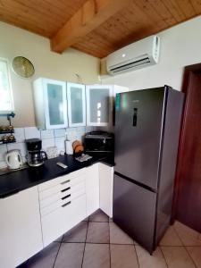 a kitchen with a stainless steel refrigerator and white cabinets at Németh Apartmanház in Balatongyörök