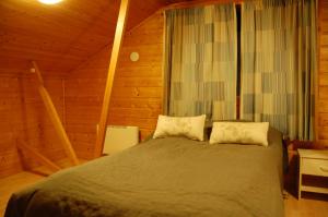 a bedroom with a bed in a wooden cabin at Cottages RukaTupa in Ruka