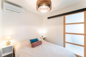 une chambre avec un lit, une lampe et une fenêtre dans l'établissement Joli T1 Bis avec Chambre - Cuisine - Salle de Bain, à Vallières