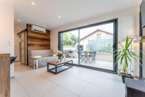 d'un salon avec une grande porte coulissante en verre. dans l'établissement Joli T1 Bis avec Chambre - Cuisine - Salle de Bain, à Vallières