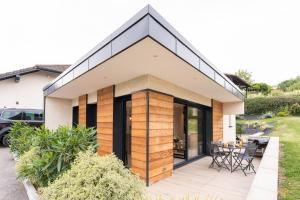 une maison avec un toit en pente et un patio dans l'établissement Joli T1 Bis avec Chambre - Cuisine - Salle de Bain, à Vallières