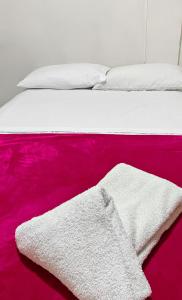 a bed with a white blanket and a red rug at hostal casa la abuela habitación 202 in Santa Rosa de Cabal