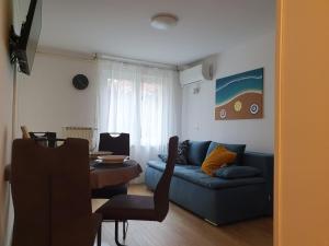 a living room with a blue couch and a table at Apartmaji Pregelj in Koper