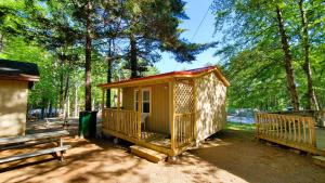 a small cabin in a park with a bench at Oakhill Pines Campground in Bridgewater