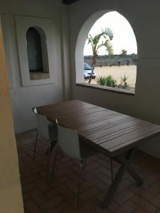 a wooden table and chairs in a room with a window at Hacienda Soto-Hego Haizea in Chiclana de la Frontera