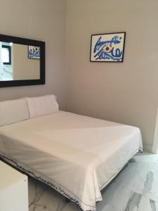 a white bed in a room with a mirror at Hacienda Soto-Hego Haizea in Chiclana de la Frontera
