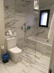 a white bathroom with a toilet and a shower at Hacienda Soto-Hego Haizea in Chiclana de la Frontera